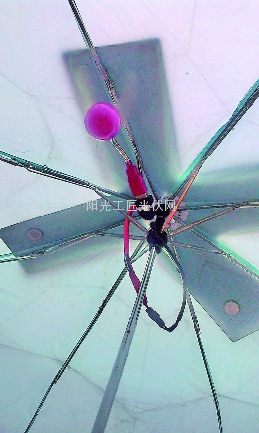 3个小学生设计的太阳能雨伞，雨伞上加装了太阳能电池板见小图。记者 张梁 摄