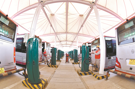 国网天津电力员工维护公交汽车充电设施。